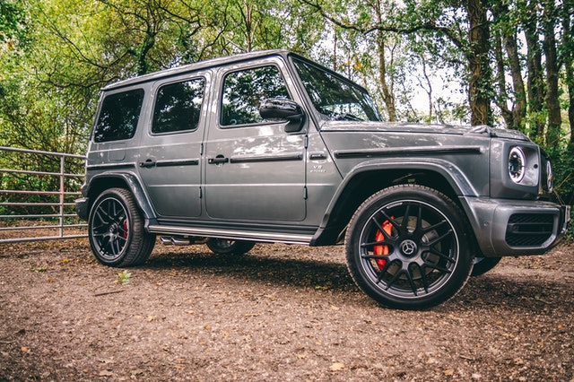 land rover parked sideways with a wooded background