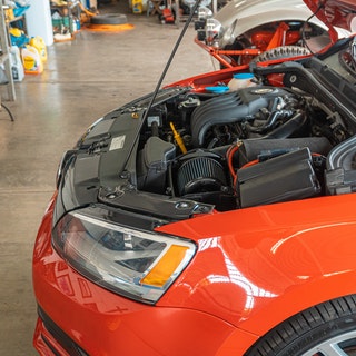 picture of a red car with its bonnet open and engine exposed