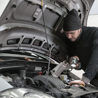 mechanic inspecting engine of car